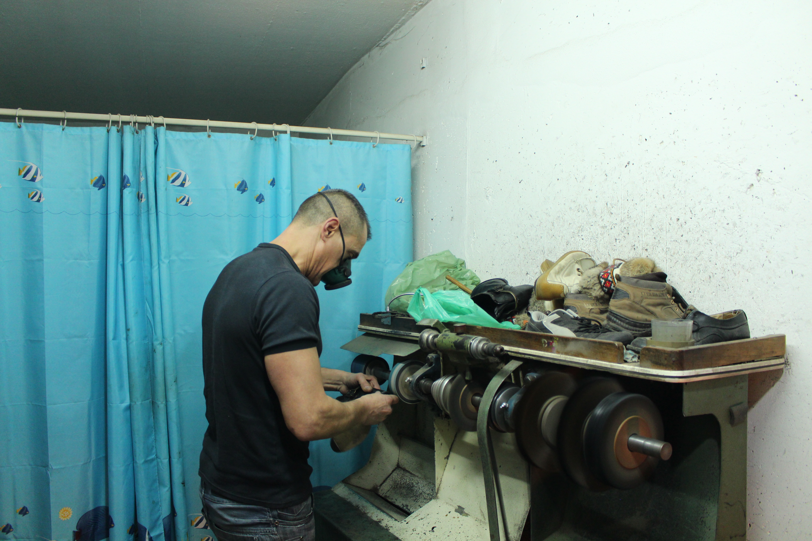 João Dias terminando um sapato junto à máquina destinada aos remates finais