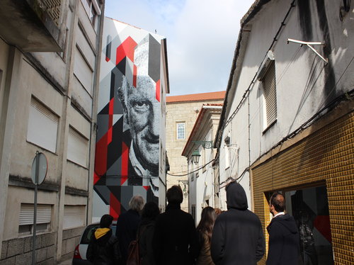 Turistas observam obra que retrata morador da zona histórica da Covilhã