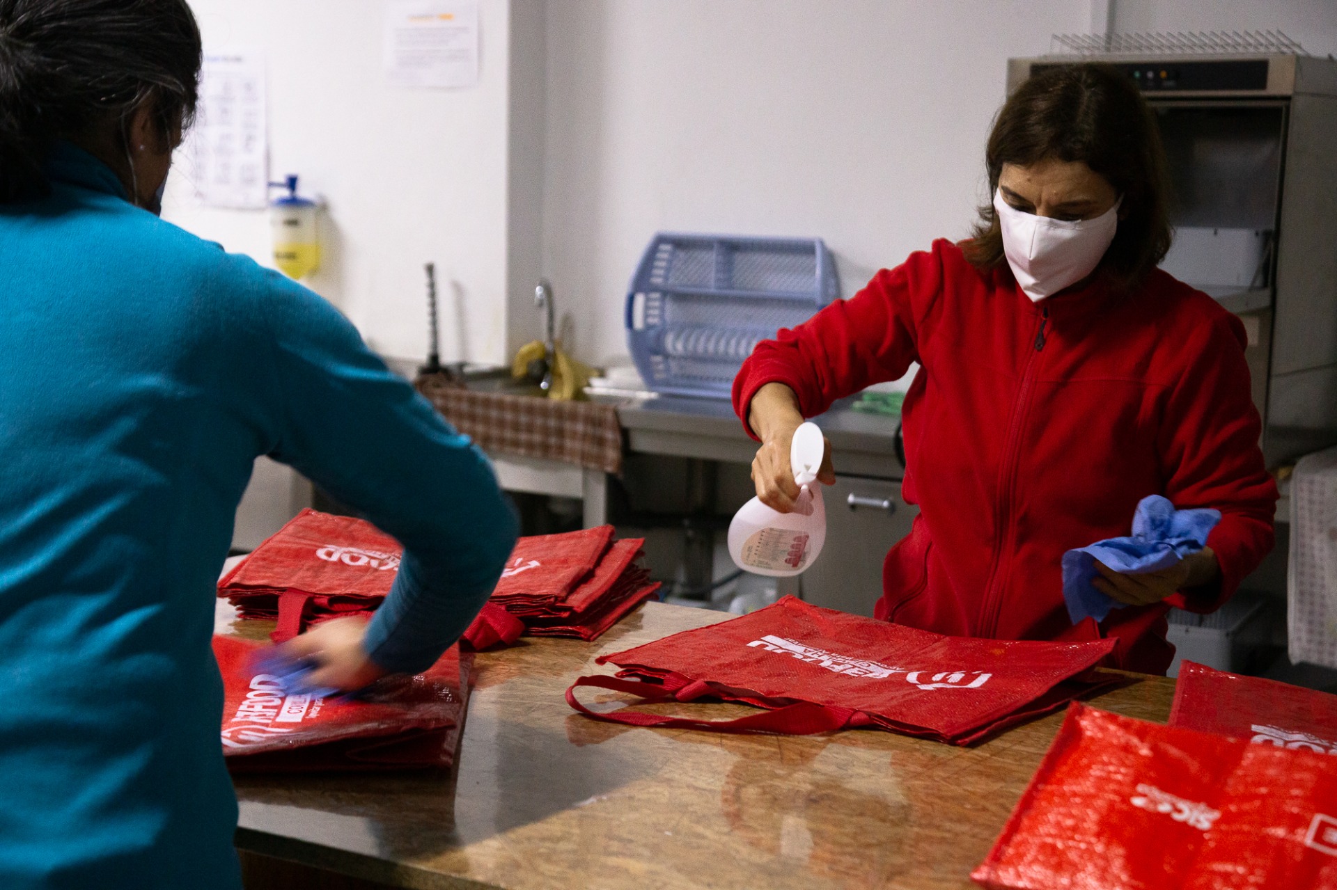 Lúcia Novais e Sofia Tomás desinfetam sacos para recolha dos alimentos 