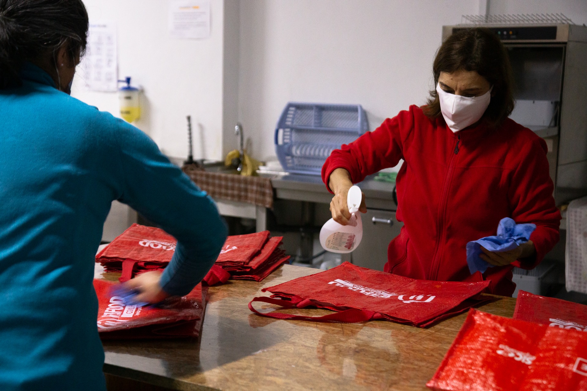 Lúcia Novais e Sofia Tomás desinfetam sacos para recolha dos alimentos 